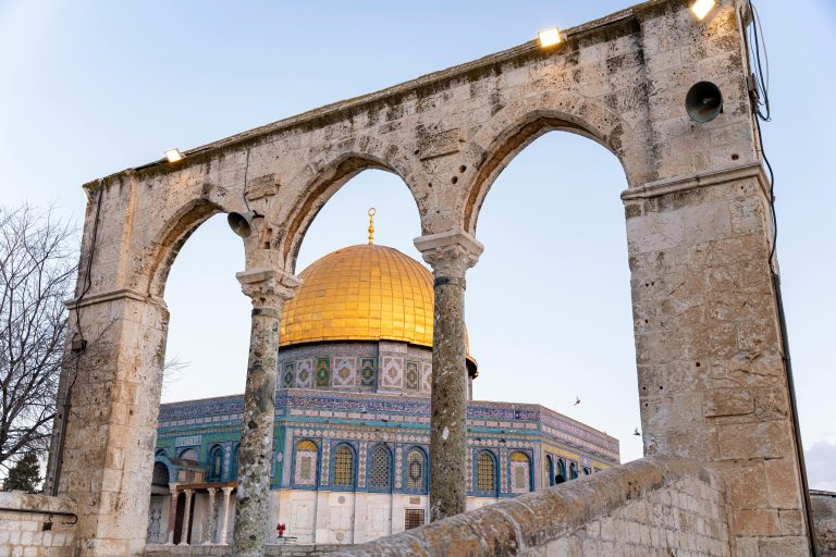 Capture of the Dome of the Rock framed by historic stone arches in Jerusalem.