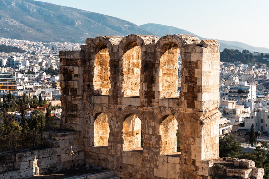 View of the ancient Odeon of Herodes Atticus in Athens with a cityscape backdrop.